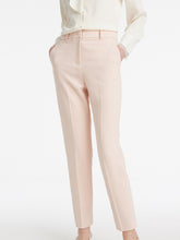 A lady wears pink cropped pants.